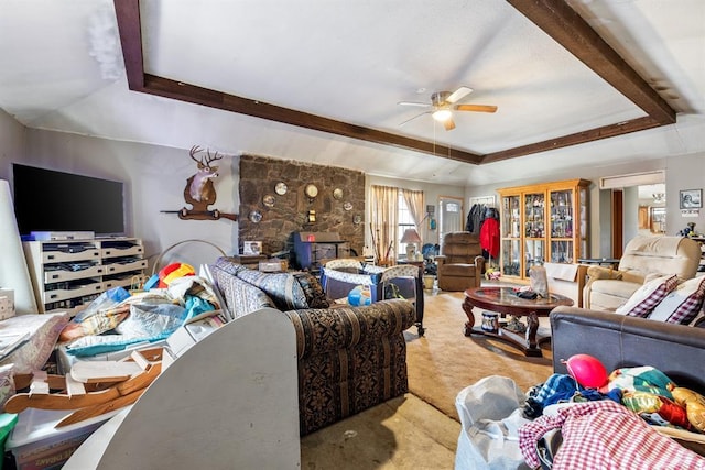 living area with a raised ceiling and ceiling fan