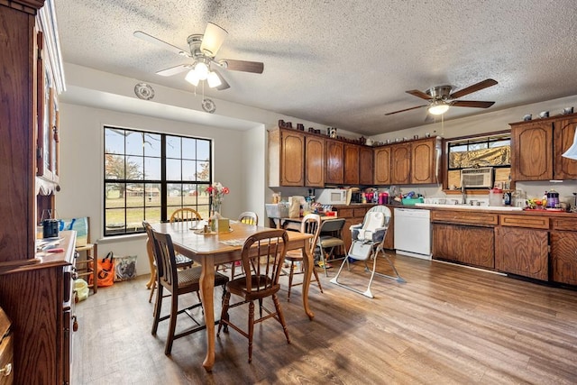 dining room with ceiling fan, a textured ceiling, and light wood finished floors