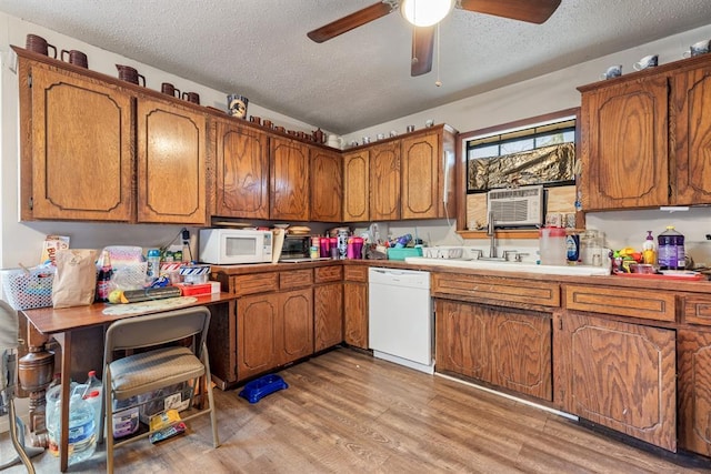 kitchen featuring white appliances, light wood-style flooring, and brown cabinets