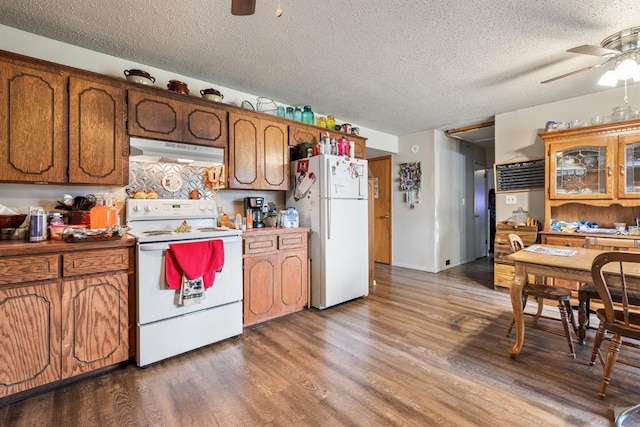 kitchen featuring a ceiling fan, white appliances, brown cabinets, and under cabinet range hood