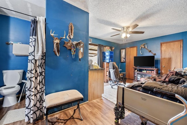 playroom featuring ceiling fan, a textured ceiling, and wood finished floors