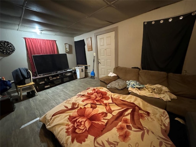 bedroom with a paneled ceiling and wood finished floors