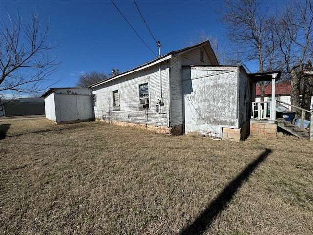 view of side of property featuring a storage unit, a lawn, and an outdoor structure