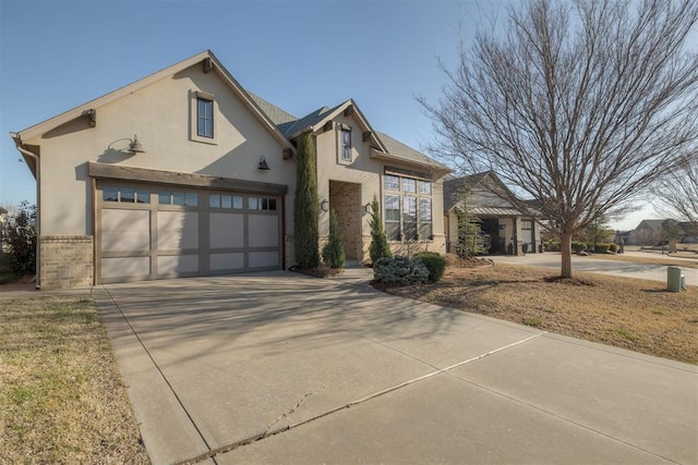 view of front of property featuring brick siding, driveway, and stucco siding