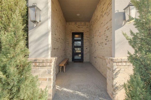 view of exterior entry featuring brick siding