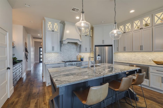 kitchen featuring visible vents, custom exhaust hood, dark wood-style flooring, a sink, and stainless steel appliances