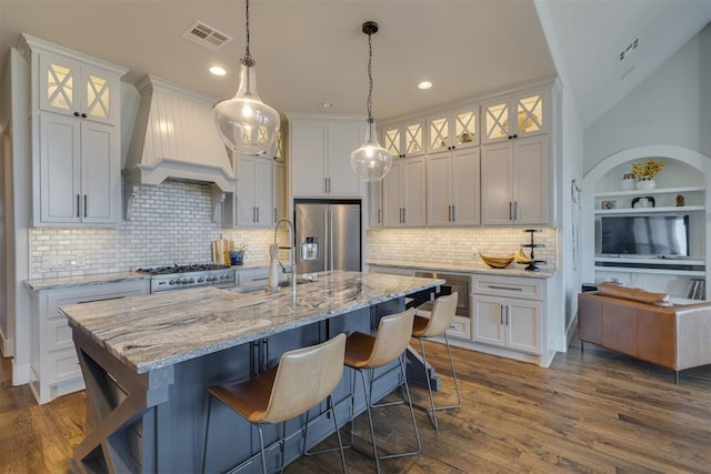 kitchen featuring a sink, stainless steel appliances, custom exhaust hood, and dark wood-style flooring