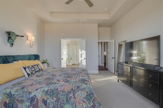 carpeted bedroom featuring a tray ceiling, a ceiling fan, visible vents, and a towering ceiling