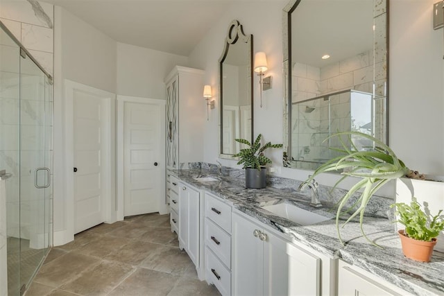 full bathroom with double vanity, a shower stall, and a sink