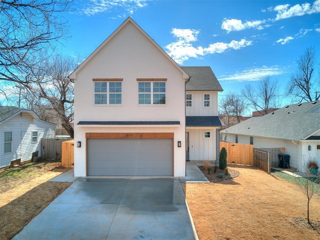 traditional home with board and batten siding, a gate, fence, a garage, and driveway