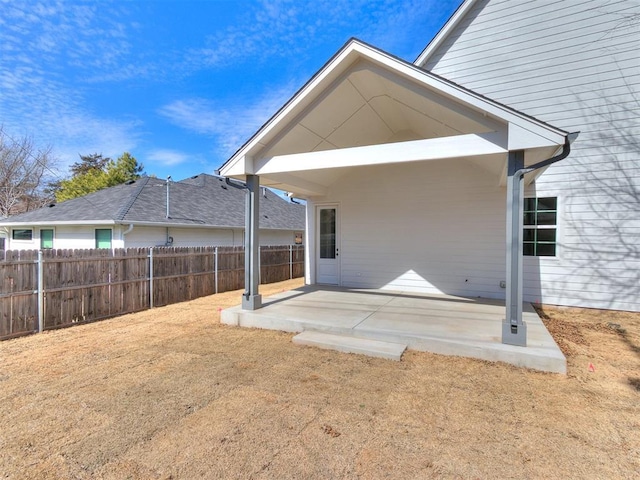 rear view of house with fence and a patio