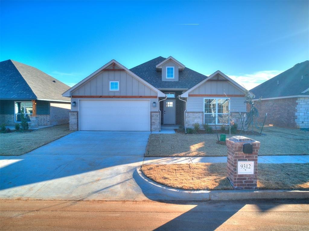 craftsman house with concrete driveway, board and batten siding, an attached garage, and roof with shingles