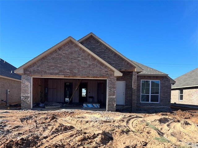 view of front of house with brick siding, roof with shingles, and an attached garage