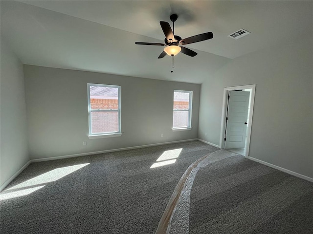 spare room featuring ceiling fan, carpet flooring, visible vents, baseboards, and vaulted ceiling