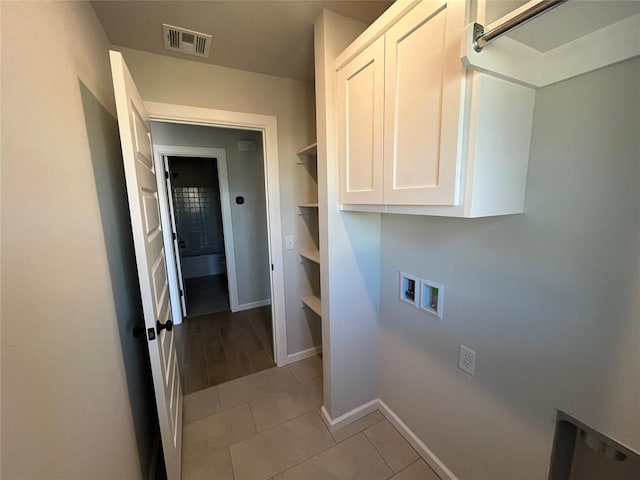 clothes washing area featuring light tile patterned floors, cabinet space, baseboards, visible vents, and hookup for a washing machine