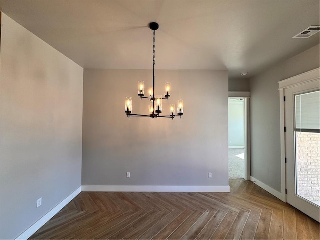 spare room with a chandelier, visible vents, plenty of natural light, and baseboards