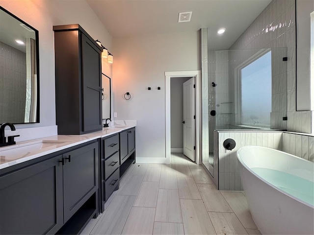 full bathroom with a freestanding tub, a sink, visible vents, double vanity, and walk in shower