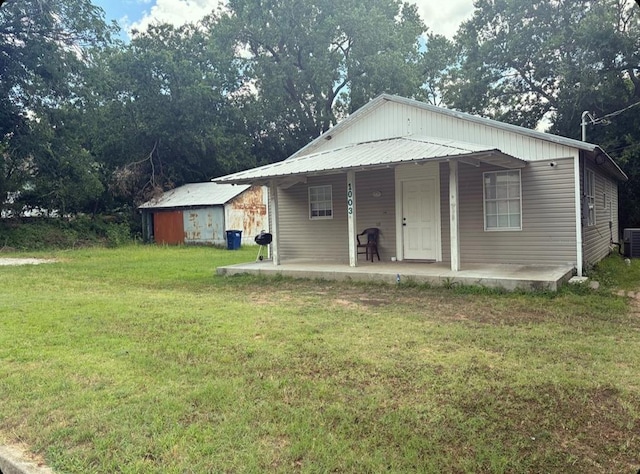 view of front of home featuring central AC, metal roof, and a front lawn