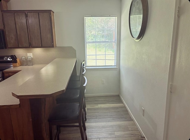 dining space featuring light wood-type flooring and baseboards