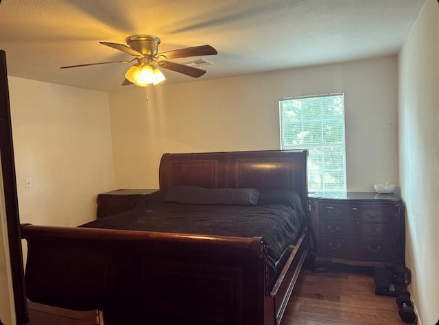 bedroom with a ceiling fan and dark wood-style flooring