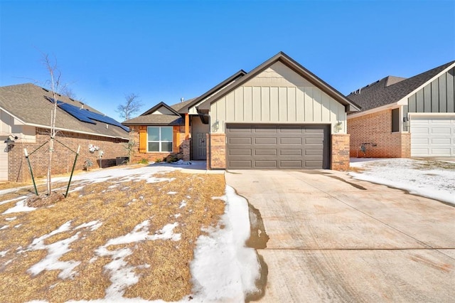 view of front of property featuring concrete driveway, brick siding, board and batten siding, and an attached garage