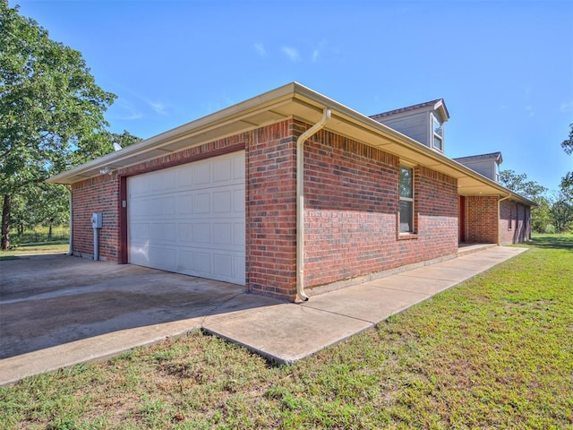 view of side of home with a garage, driveway, and brick siding