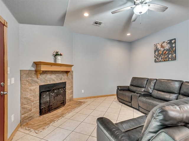 living area with visible vents, light tile patterned flooring, ceiling fan, a tile fireplace, and baseboards