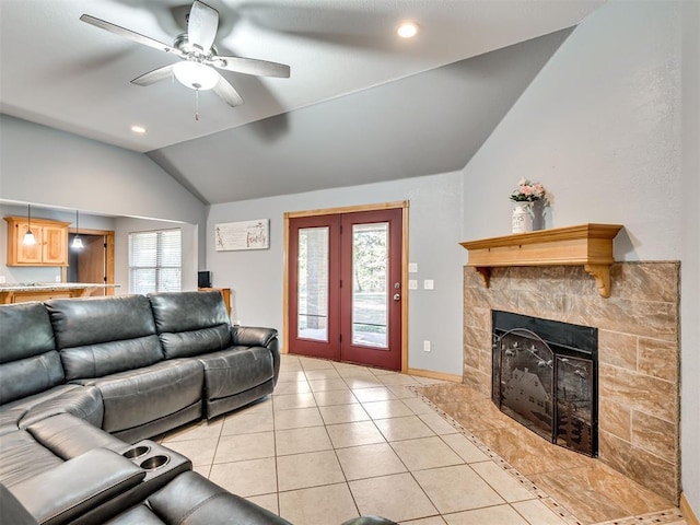 living area with lofted ceiling, light tile patterned floors, plenty of natural light, and a fireplace