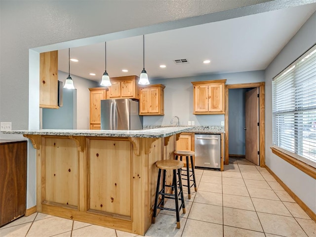 kitchen featuring stainless steel appliances, visible vents, hanging light fixtures, light tile patterned flooring, and a peninsula