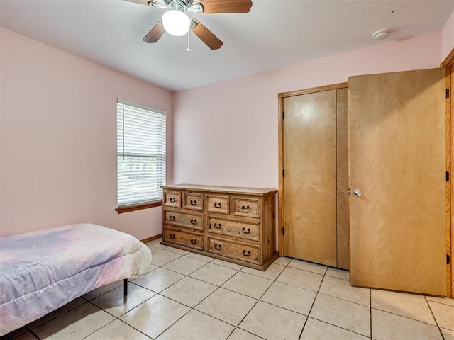 bedroom with a ceiling fan, a closet, and light tile patterned floors