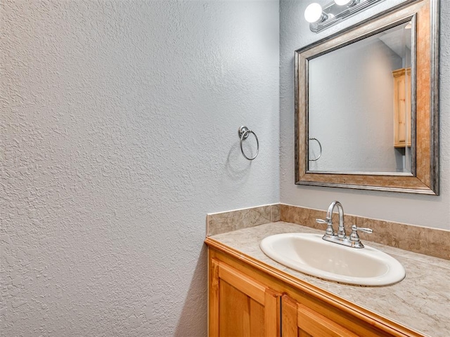 bathroom featuring a textured wall and vanity