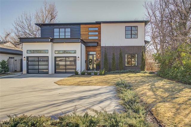 modern home featuring a garage, driveway, and stucco siding