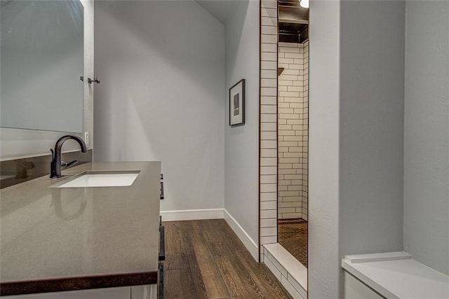 1212 W Wilshire Blvd, Nichols Hills, OK 73116 - full bathroom with wood finished floors, a tile shower, vanity, and baseboards