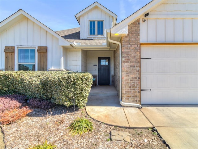 doorway to property with a garage, a shingled roof, and board and batten siding