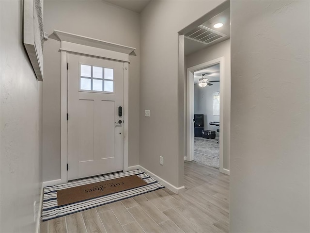 entrance foyer featuring baseboards, a healthy amount of sunlight, visible vents, and light wood-style floors