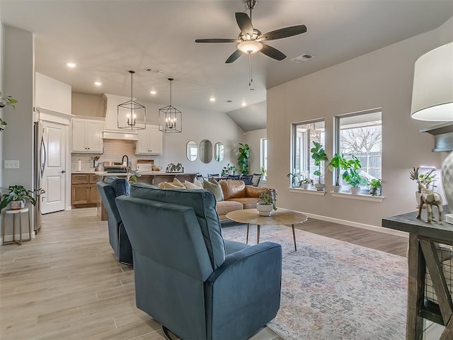 living area with visible vents, ceiling fan, and light wood finished floors