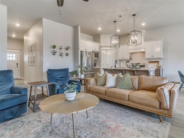 living room featuring recessed lighting, visible vents, and light wood finished floors