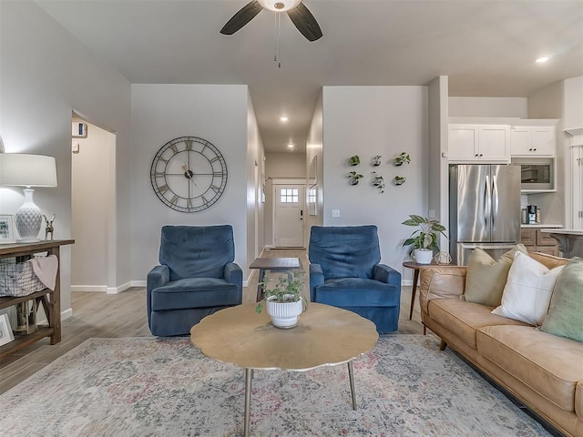 living area with light wood finished floors, recessed lighting, a ceiling fan, and baseboards