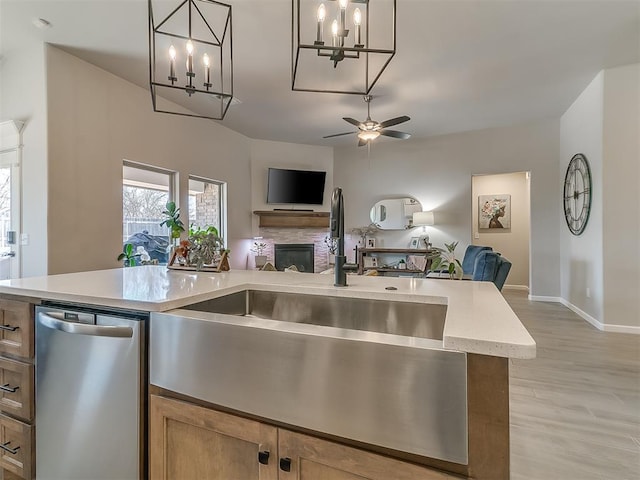 kitchen with open floor plan, light countertops, a sink, and decorative light fixtures