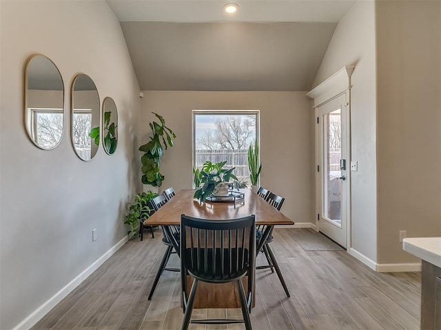 dining room with light wood-style floors, lofted ceiling, baseboards, and recessed lighting