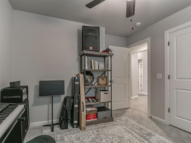 interior space with light carpet, ceiling fan, and baseboards