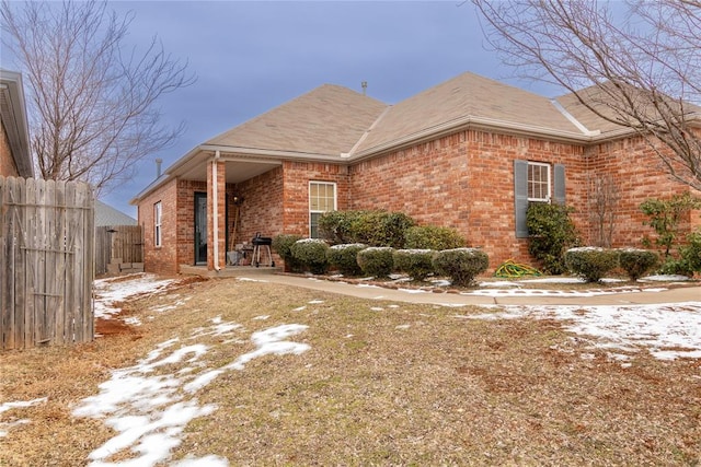 view of front facade featuring brick siding and fence