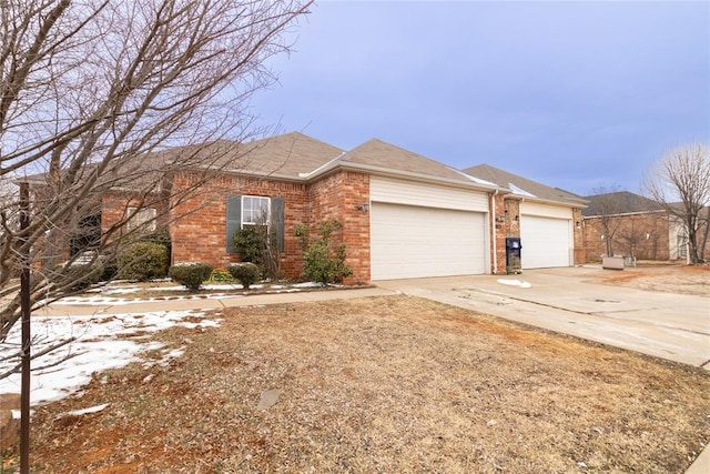 single story home with a garage, brick siding, and driveway