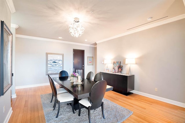 dining space featuring crown molding, baseboards, a notable chandelier, and light wood finished floors