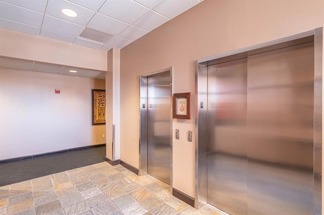 200 S Oklahoma Ave Unit 305, Oklahoma City, OK 73104 - hall featuring elevator, stone finish flooring, a paneled ceiling, and recessed lighting
