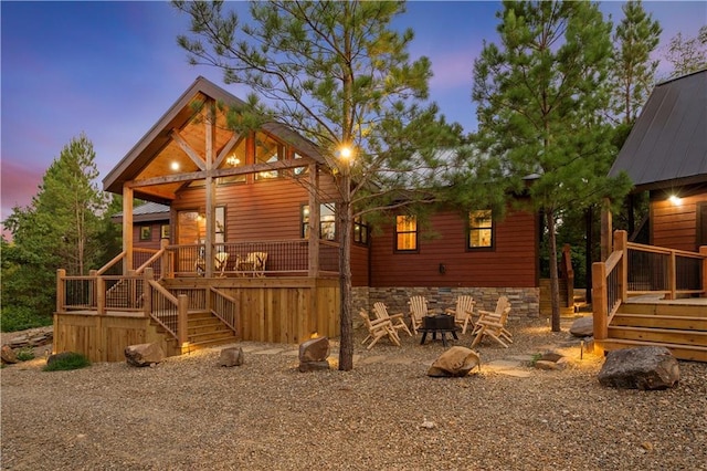 view of property exterior featuring an outdoor fire pit and stairs