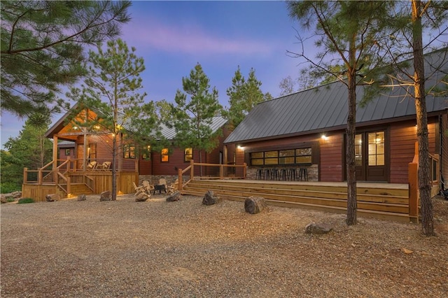 exterior space with stone siding, metal roof, and a deck