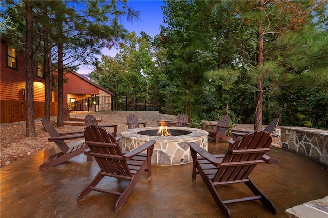 view of patio with an outdoor fire pit and fence