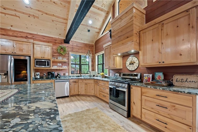 kitchen with appliances with stainless steel finishes, dark stone counters, beam ceiling, and light brown cabinets