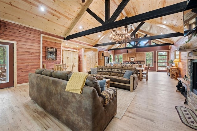 living area featuring light wood-style floors, wood walls, and high vaulted ceiling